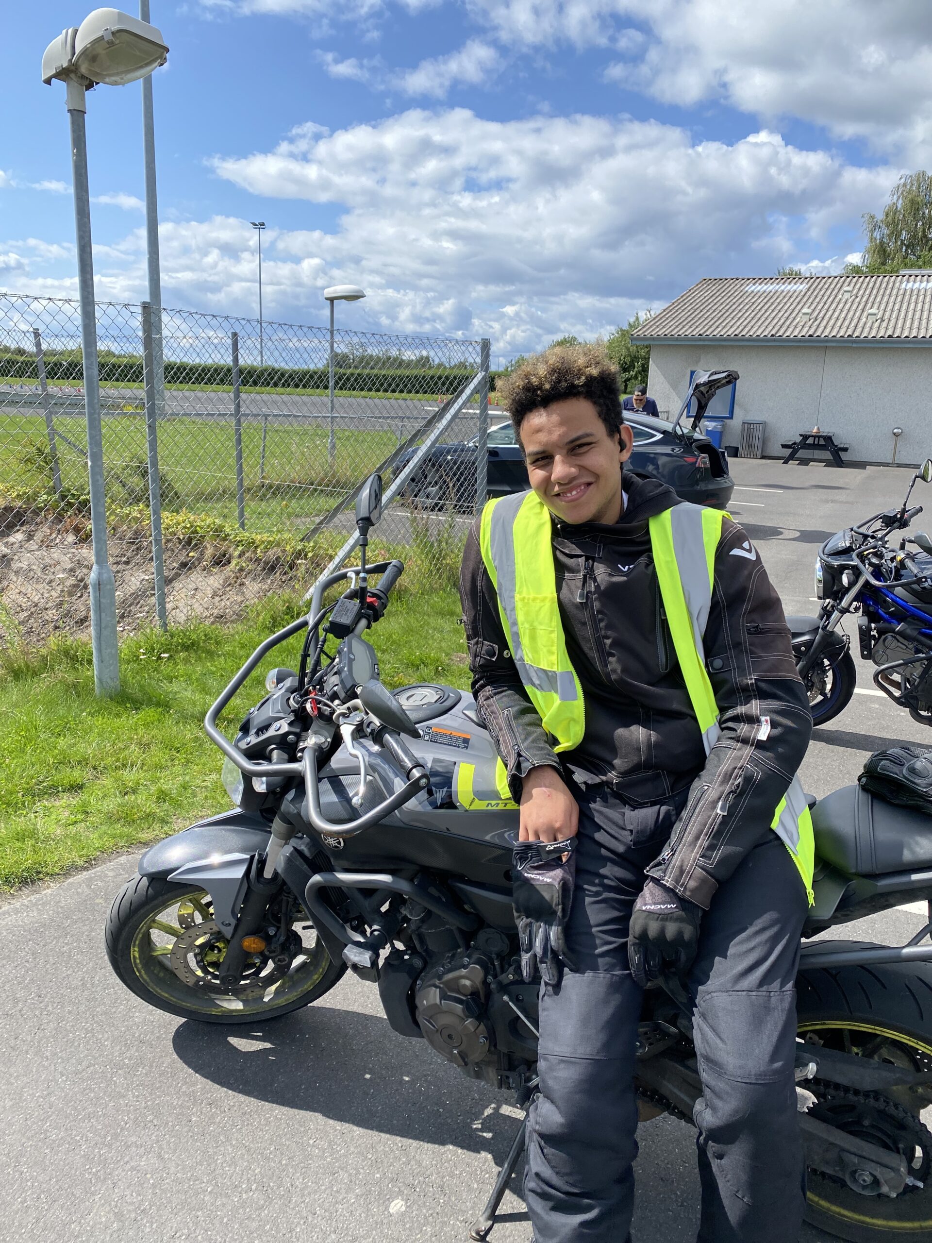 En af skolens tidligere elever som sidder på en motorcykel lige efter køreprøven hos Vores Trafikskole - amagers bedste køreskole